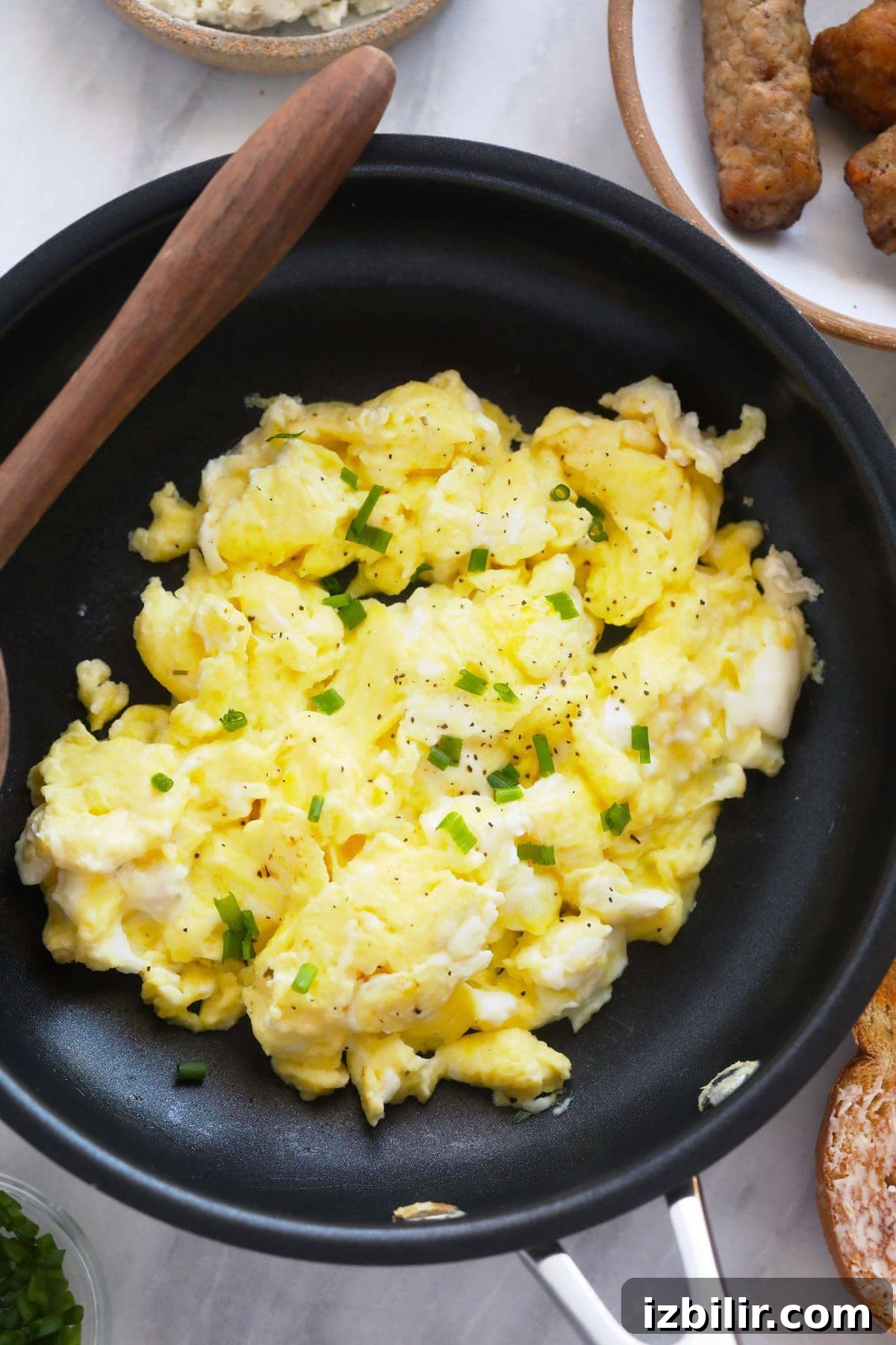 Perfect scrambled eggs topped with chives perfect scrambled eggs in a skillet topped with chopped chives