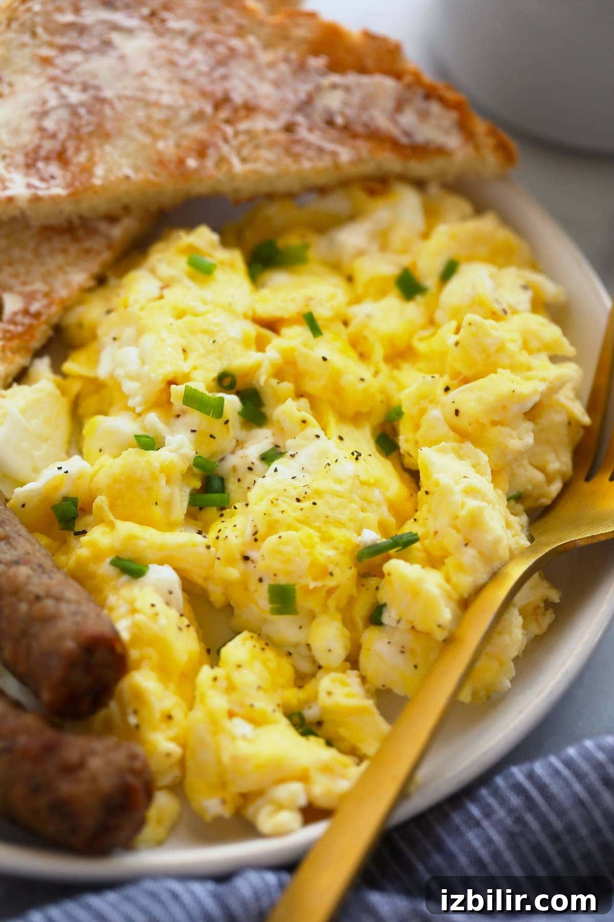Scrambled eggs served with toast and sausage perfect scrambled eggs on a plate with toast and sausage links, ready to be served