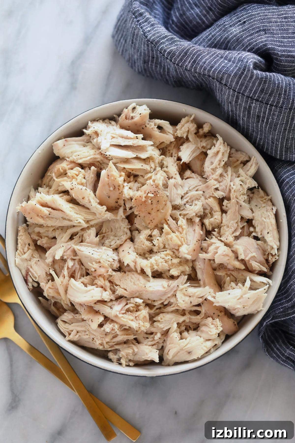 Wondering how to make the easiest shredded chicken? Look no further! This shredded chicken is baked to perfection, and will easily become a meal-prep staple in your home. baked shredded chicken in a bowl