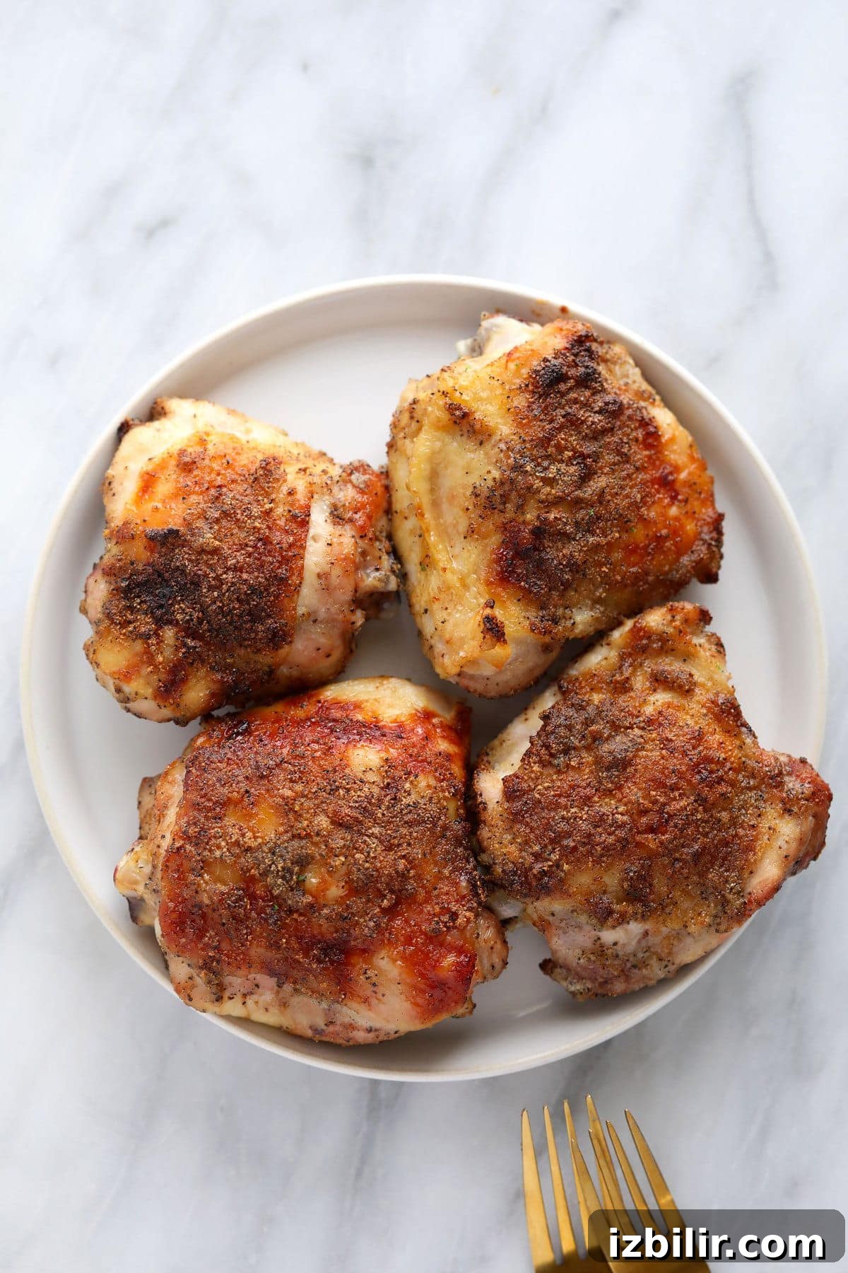 Crispy Oven-Baked Chicken Thighs with Garlic and Herbs 8 Baked chicken thighs on a plate.