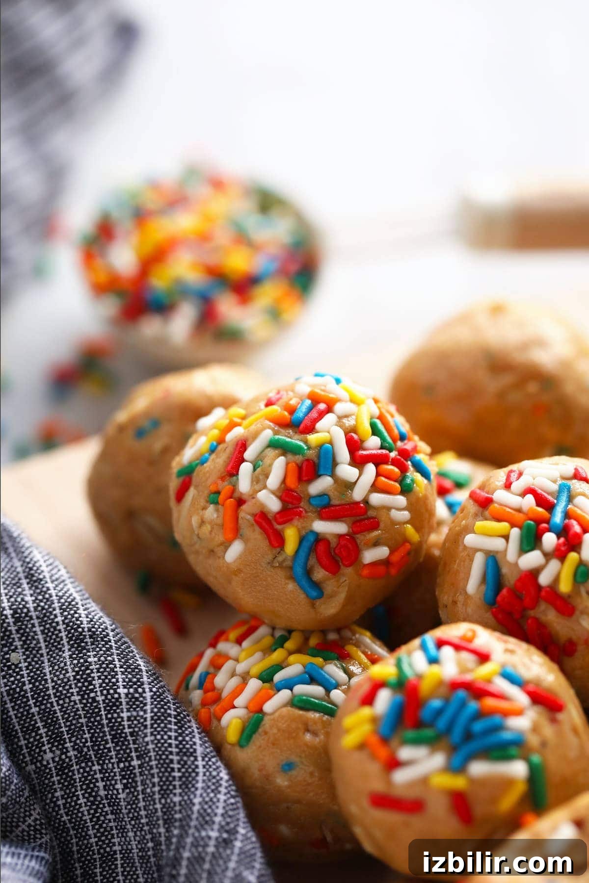 cake batter protein balls covered in rainbow sprinkles on a plate