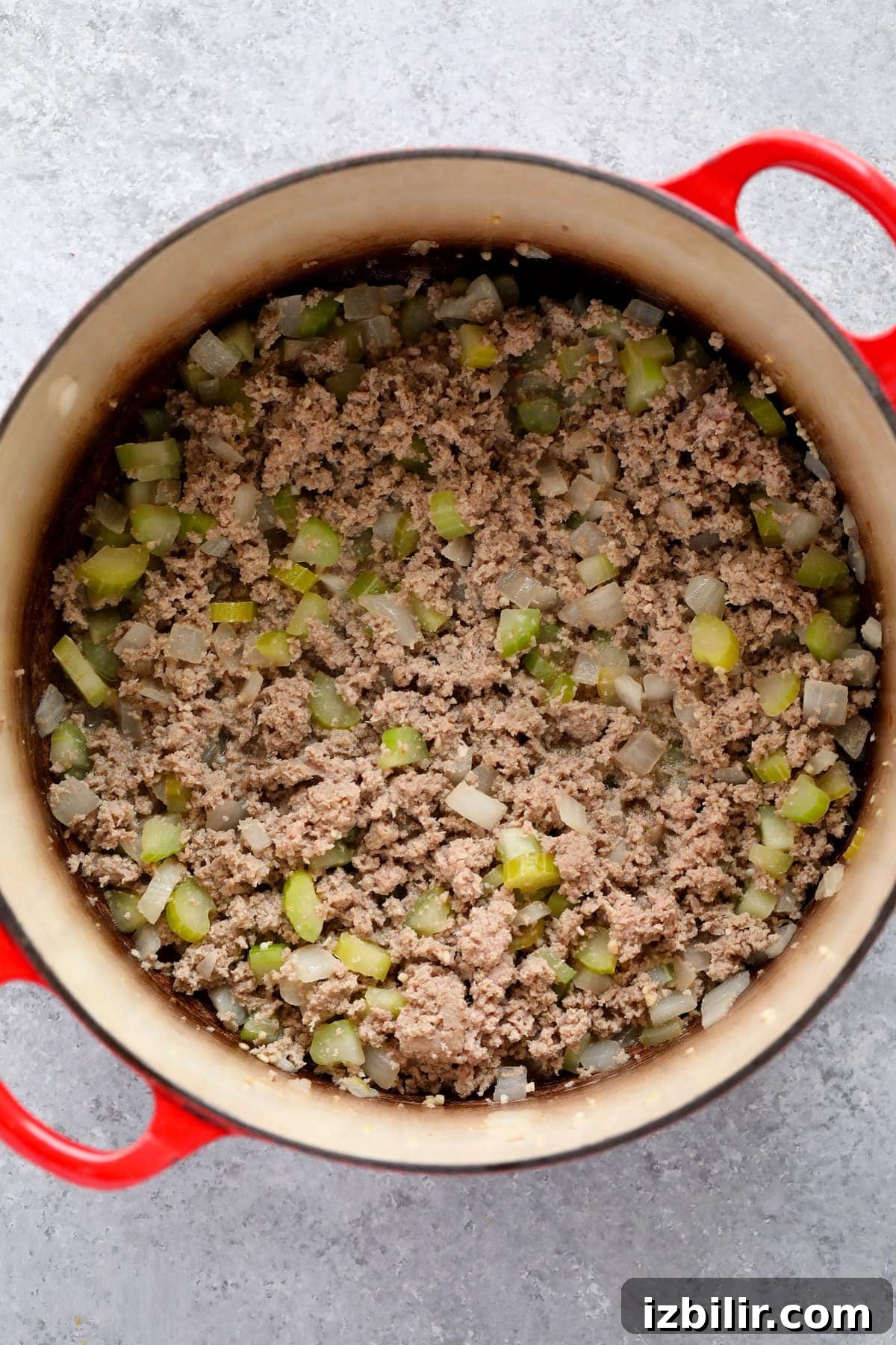 Ground turkey and vegetables being sauteed in a dutch oven for turkey chili.