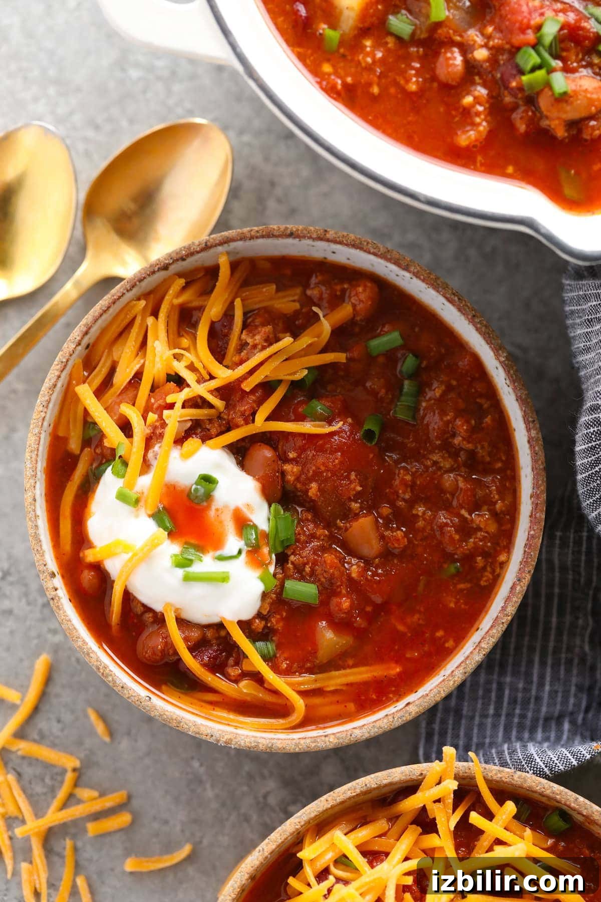 Turkey chili topped with sour cream and shredded cheese in a bowl.