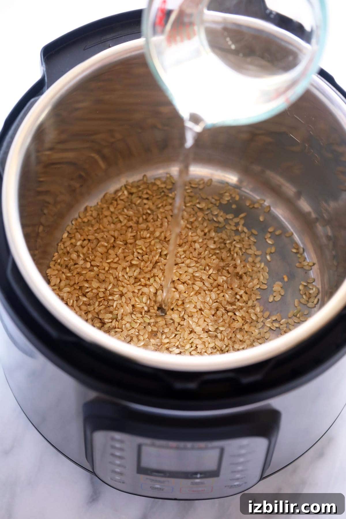 Perfect Instant Pot Brown Rice Every Time 2 Pouring water into the Instant Pot with the brown rice.