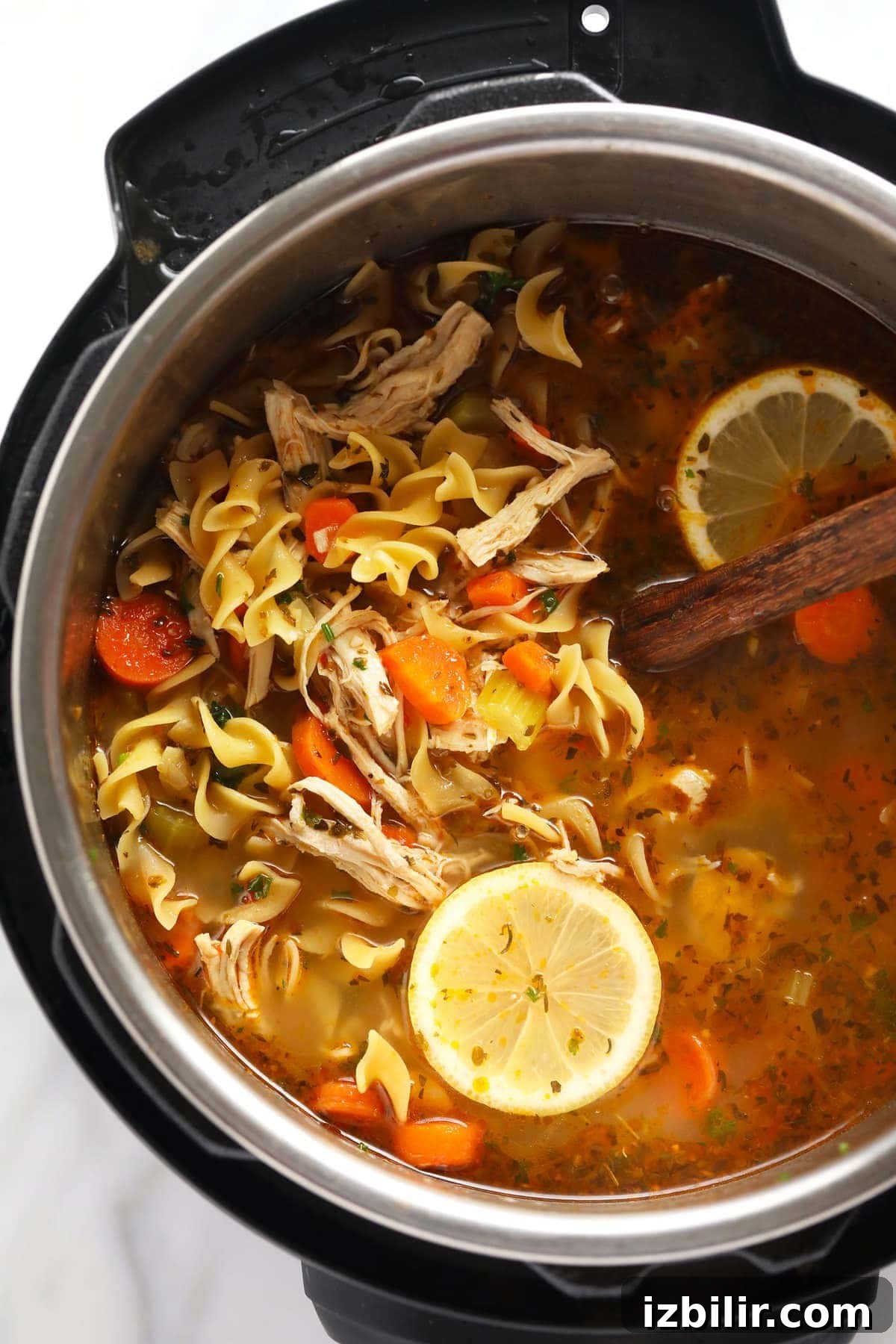 Instant Pot chicken noodle soup in IP with lemon wedge