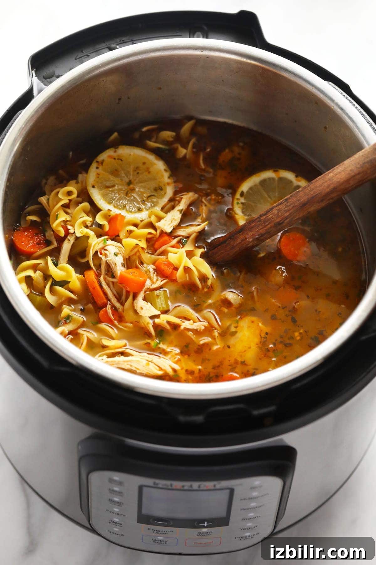 Instant Pot chicken Noodle Soup in Instant Pot with wooden spoon