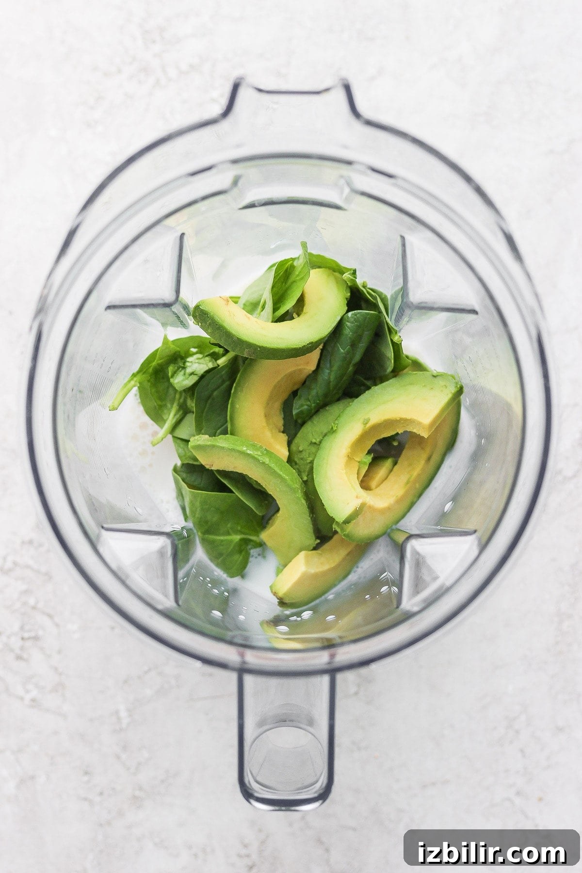 avocado smoothie ingredients in a blender, ready to be blended