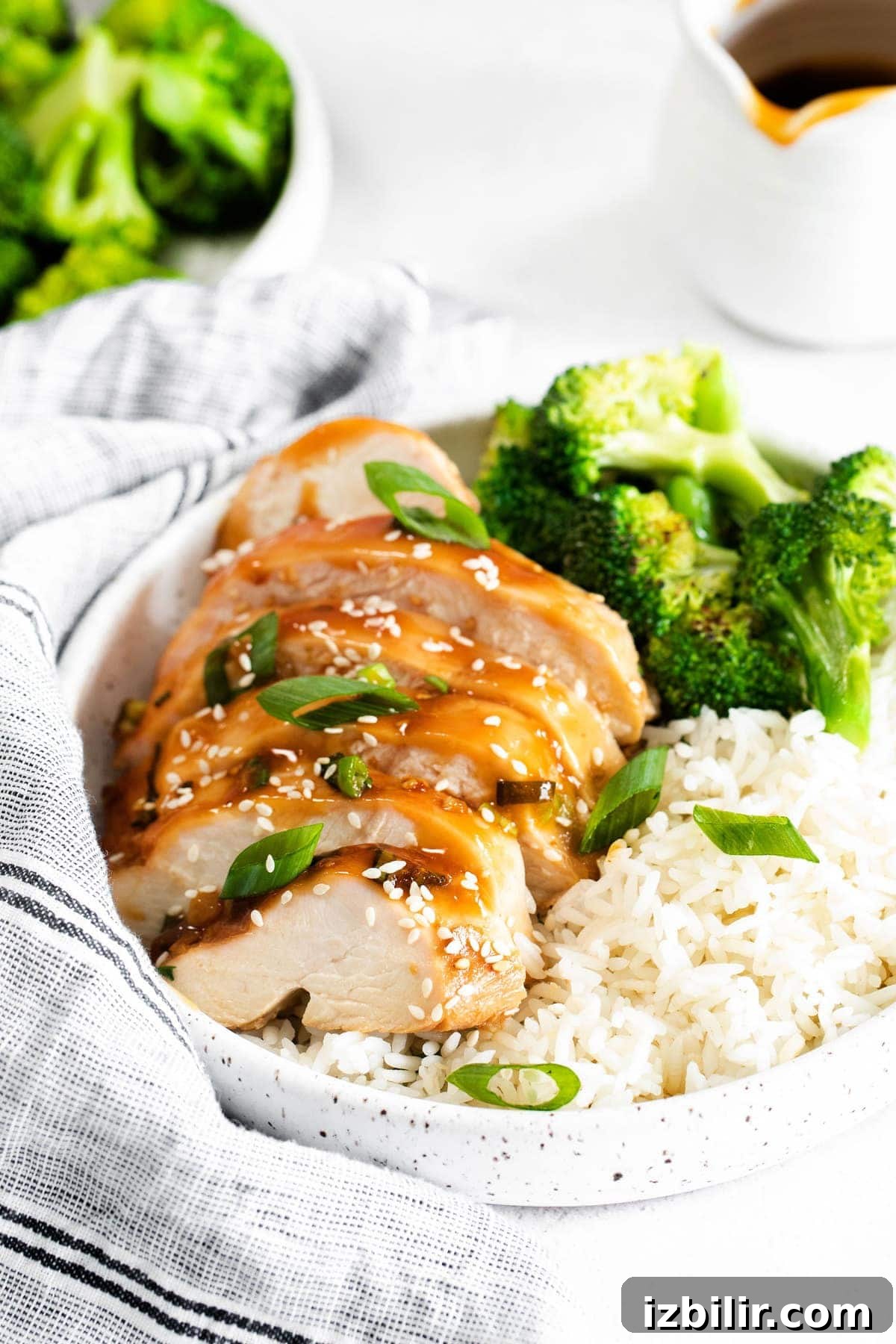 Sliced teriyaki chicken served with rice and broccoli. sliced teriyaki chicken with white rice and broccoli in bowl
