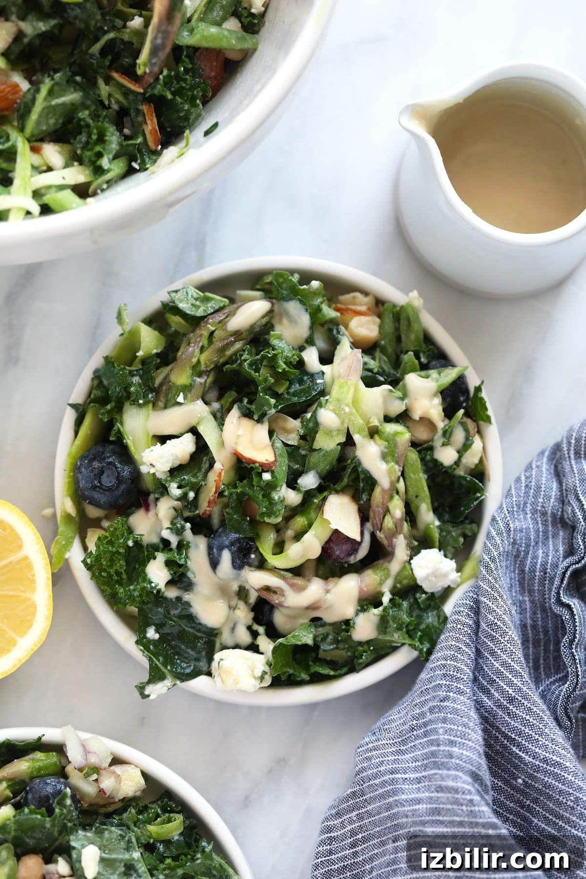 Spring Asparagus Salad with Lemon Vinaigrette 2 A bowl of asparagus salad and dressing on the side.