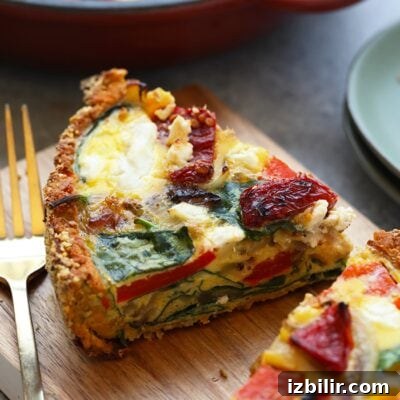 A slice of sweet potato crust quiche on a cutting board.