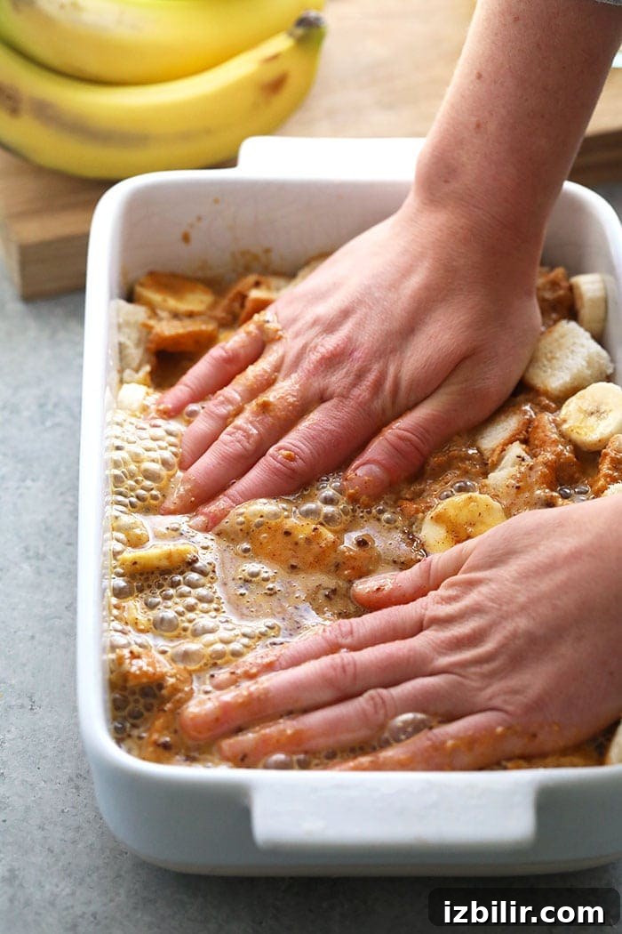 Serving Peanut Butter Banana French Toast Bake Hands in casserole