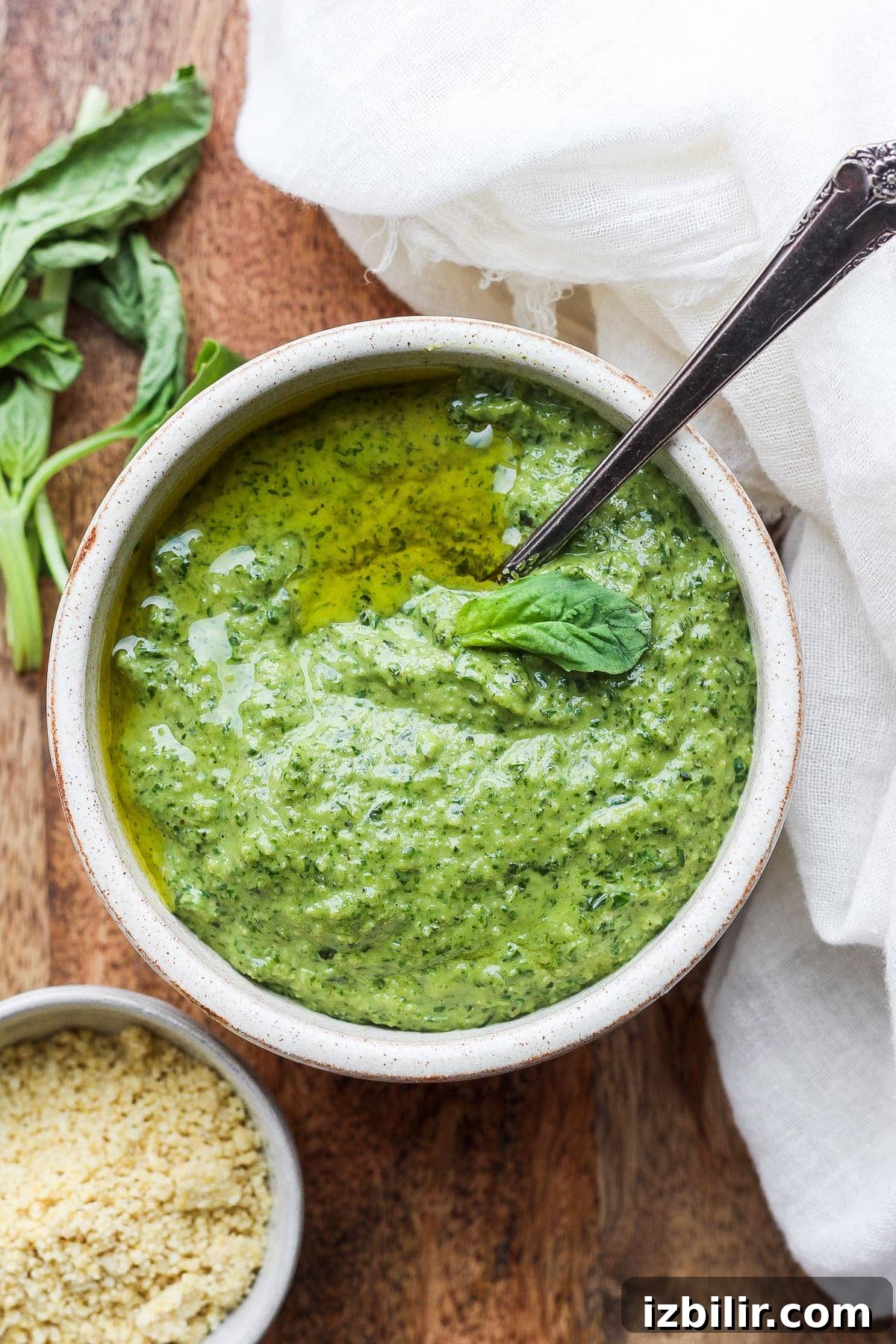 Vegan pesto is light, fresh, and 100% plant-based. It comes together with fresh basil, lemon, olive oil, garlic, and vegan parmesan cheese! pesto in bowl with spoon