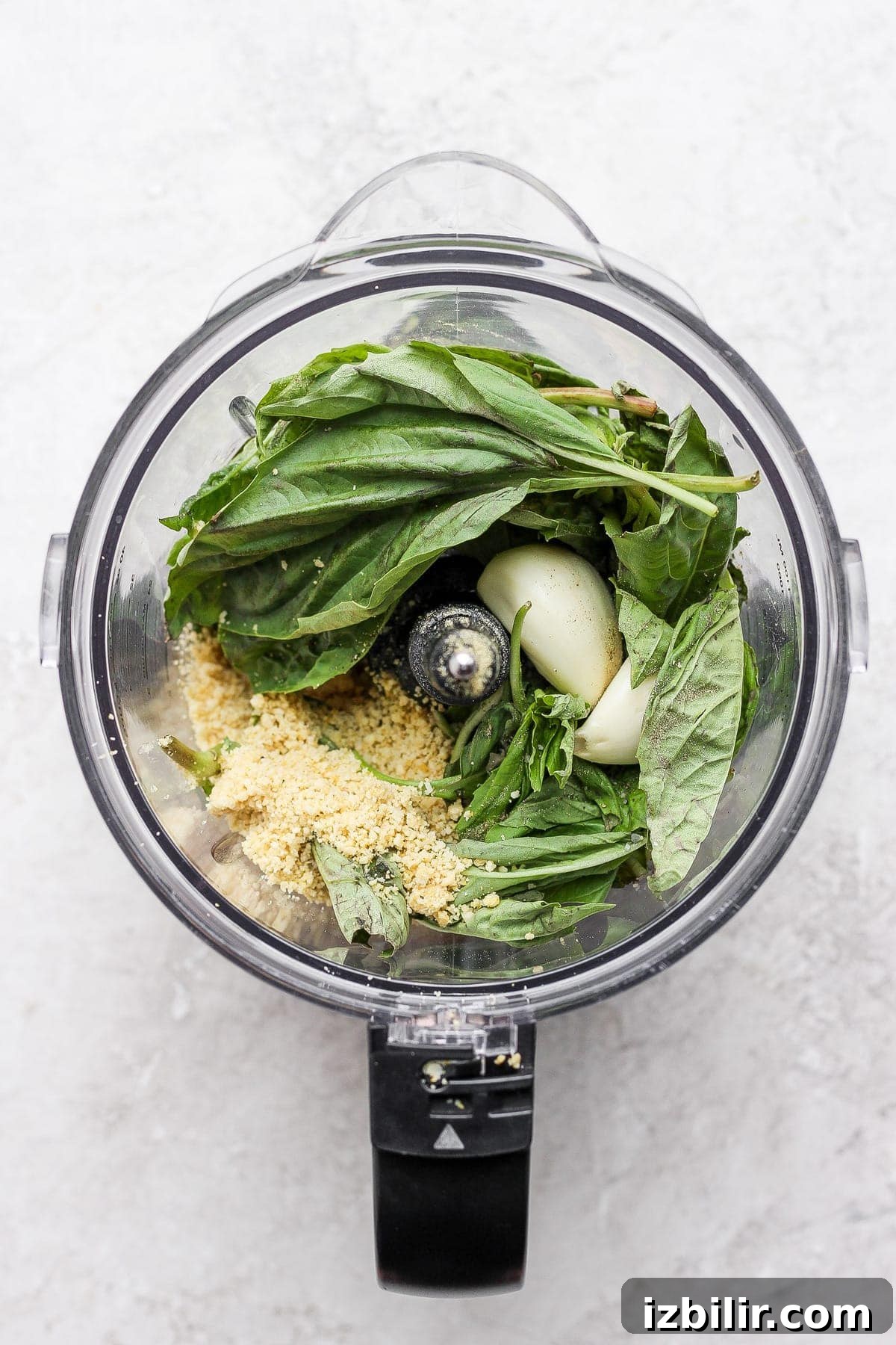 Make this simple vegan pesto recipe with fresh basil, olive oil, lemon juice, and a homemade vegan parmesan cheese. pesto ingredients in food processor