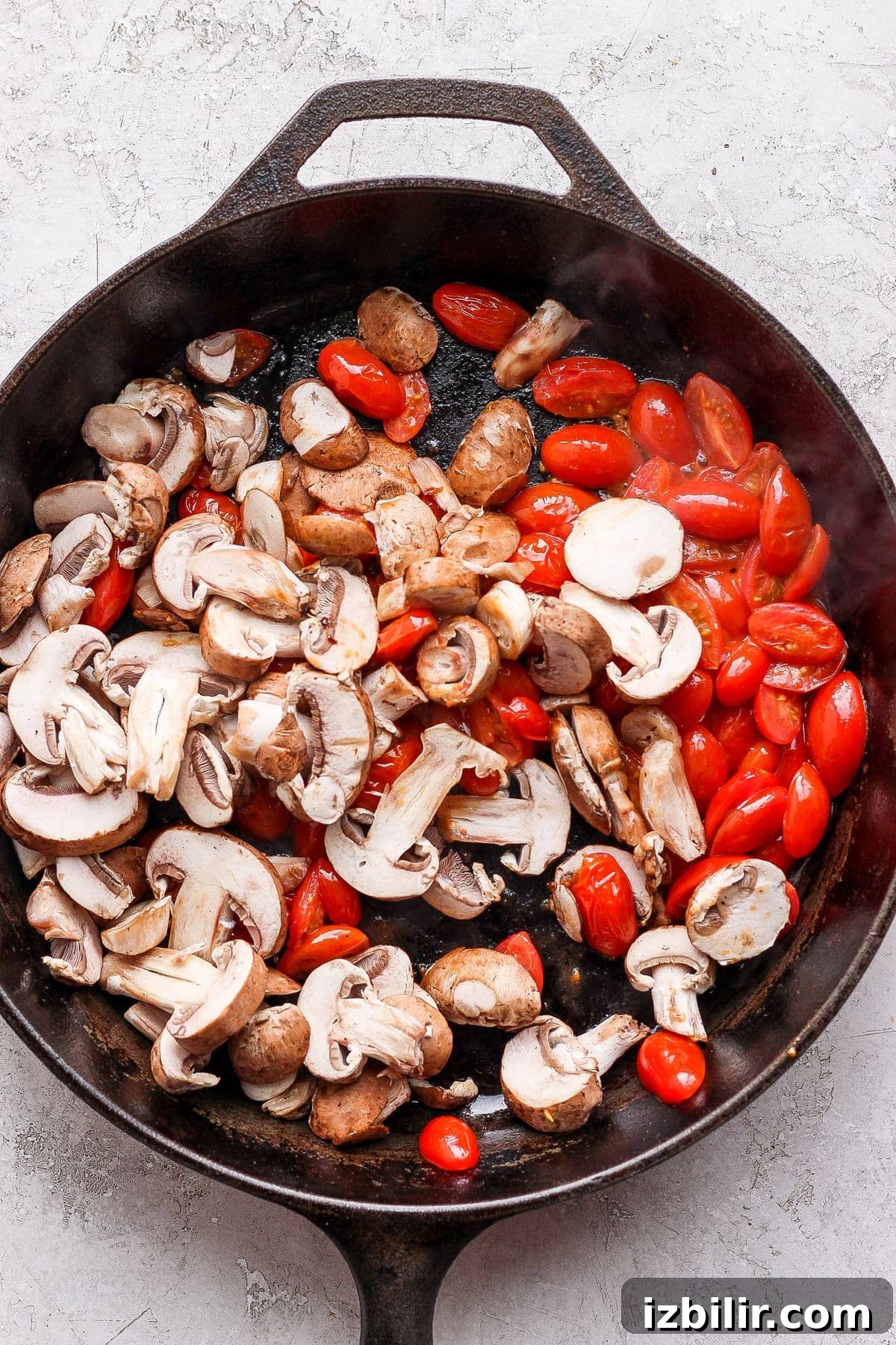Tomatoes and mushrooms in a cast iron skillet.