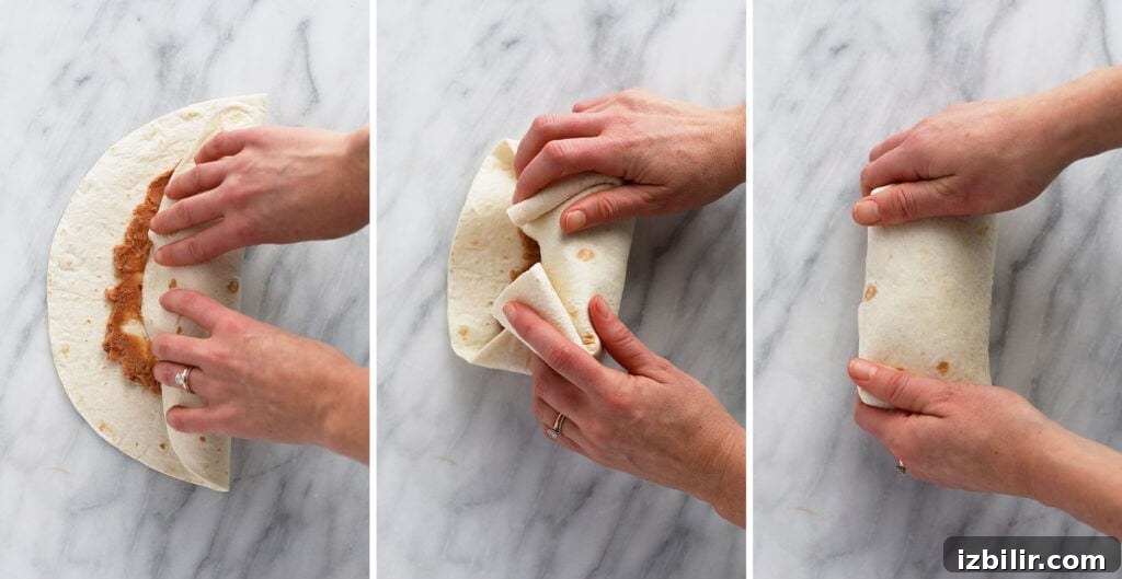 Shredded chicken burrito being rolled up.