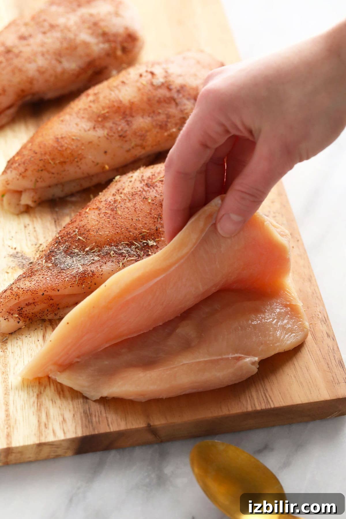 Chicken breast cut to create a pocket for stuffing raw chicken breast cut open, ready to be stuffed with broccoli and cheese filling.