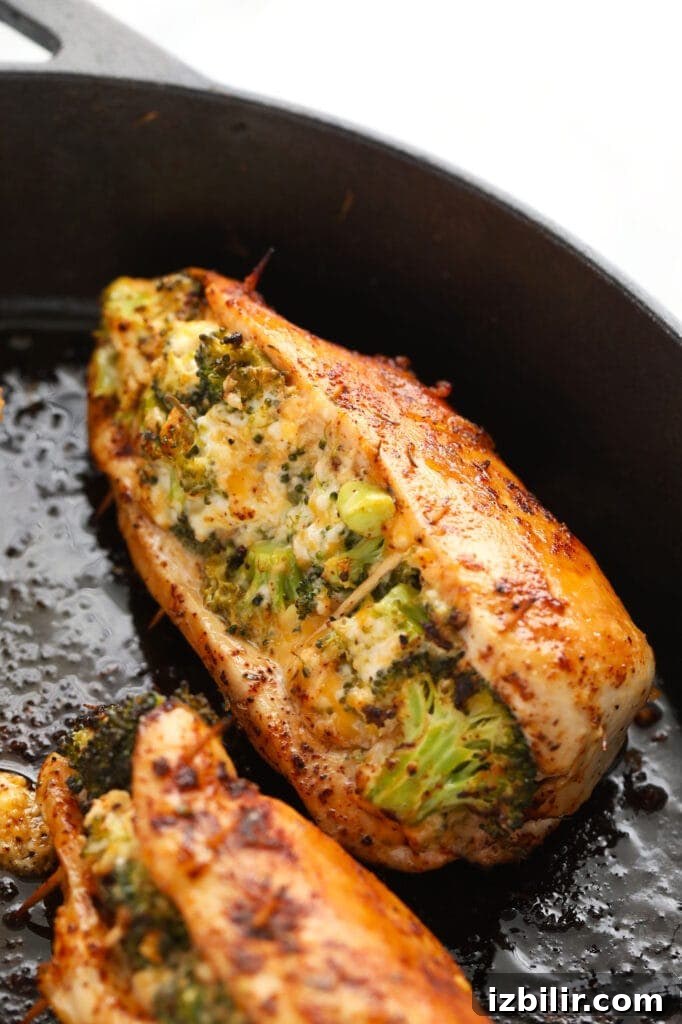 Finished broccoli and cheese stuffed chicken breasts broccoli and cheese stuffed chicken breasts in a cast iron skillet.