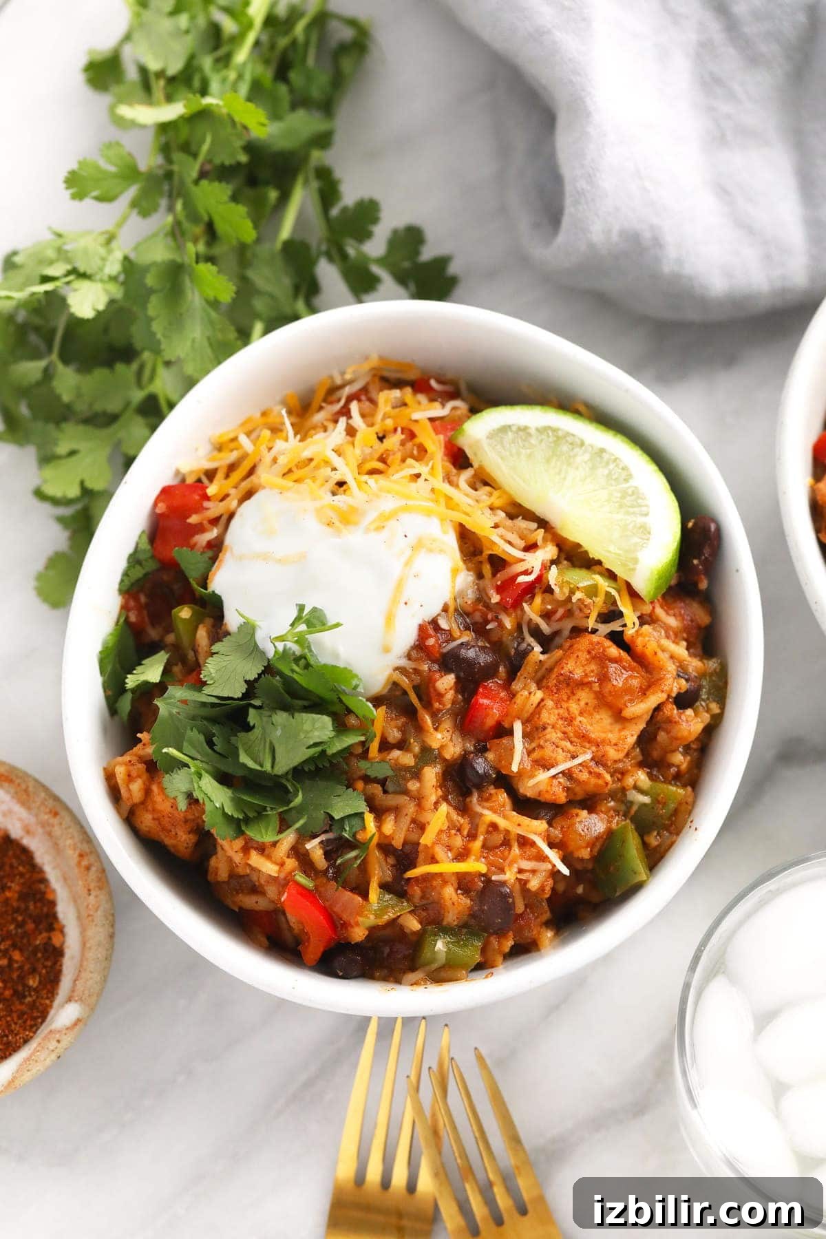 instant pot burrito bowl topped with shredded cheese and greek yogurt and cilantro