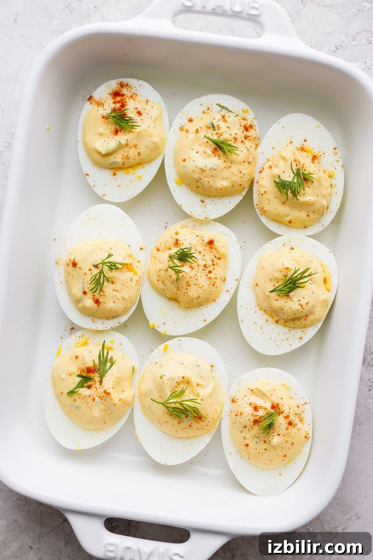 These easy deviled eggs are seriously easy to make with simple ingredients and flavor you'll love. Make a batch of these delicious deviled eggs today! easy deviled eggs in a dish garnished with paprika and fresh dill