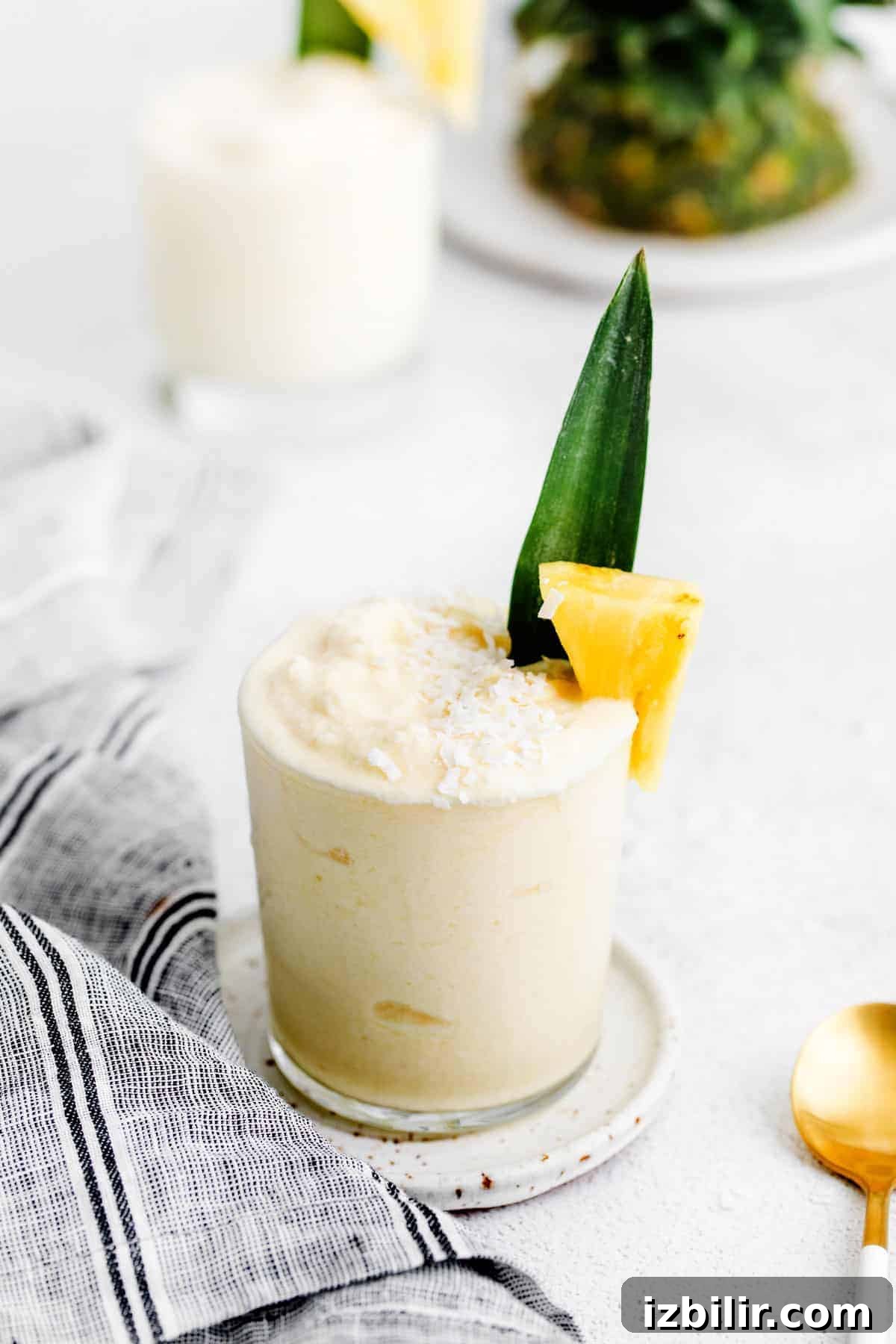 piña colada in glass with pineapple chunk
