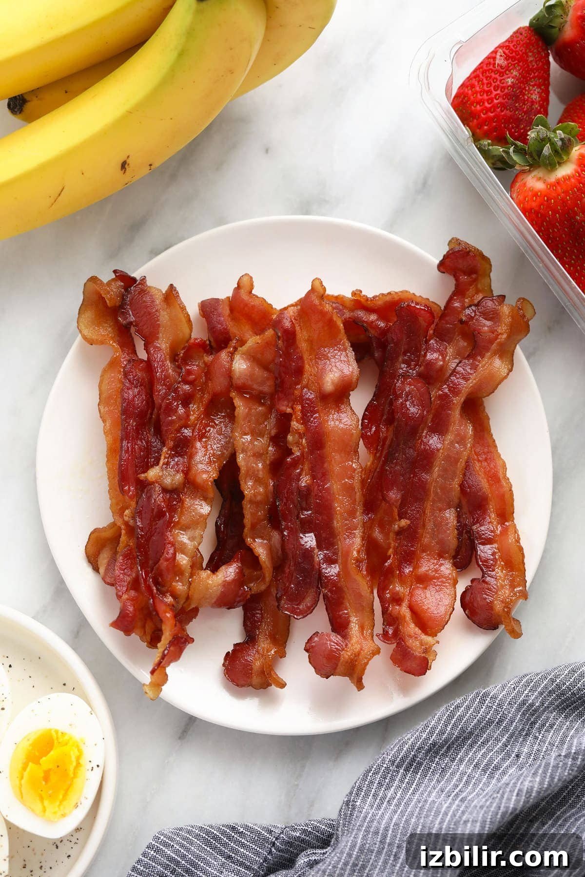 Crispy Microwave Bacon in Minutes 2 A pile of bacon on a plate.