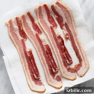 Crispy Microwave Bacon in Minutes 6 uncooked bacon on plate.