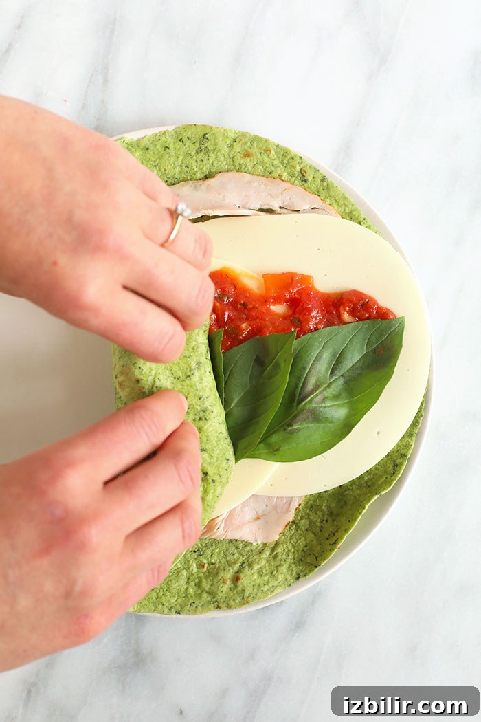 rolling a turkey pinwheel on a cutting board