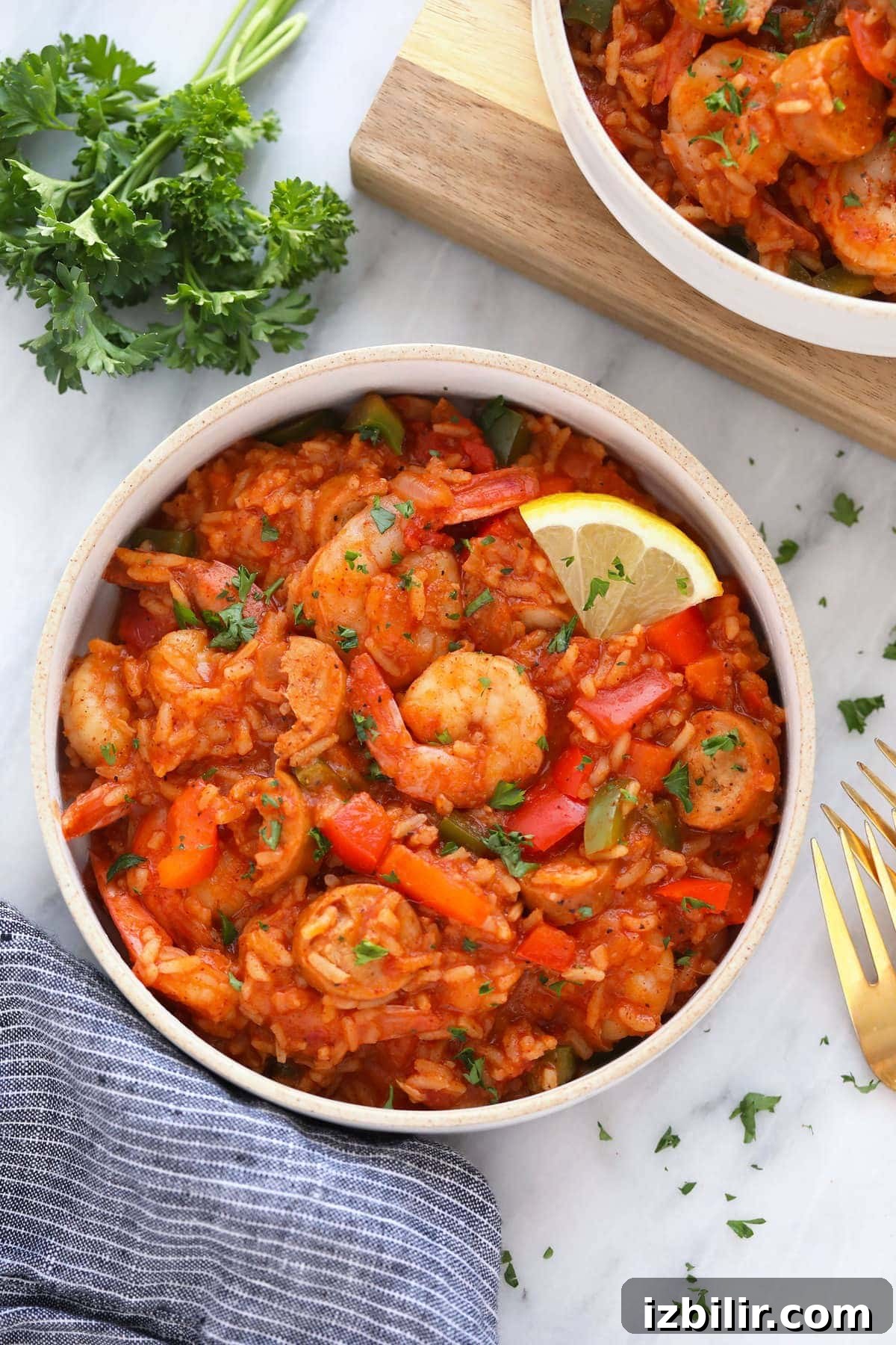 A bowl of jambalaya with a lemon slice.