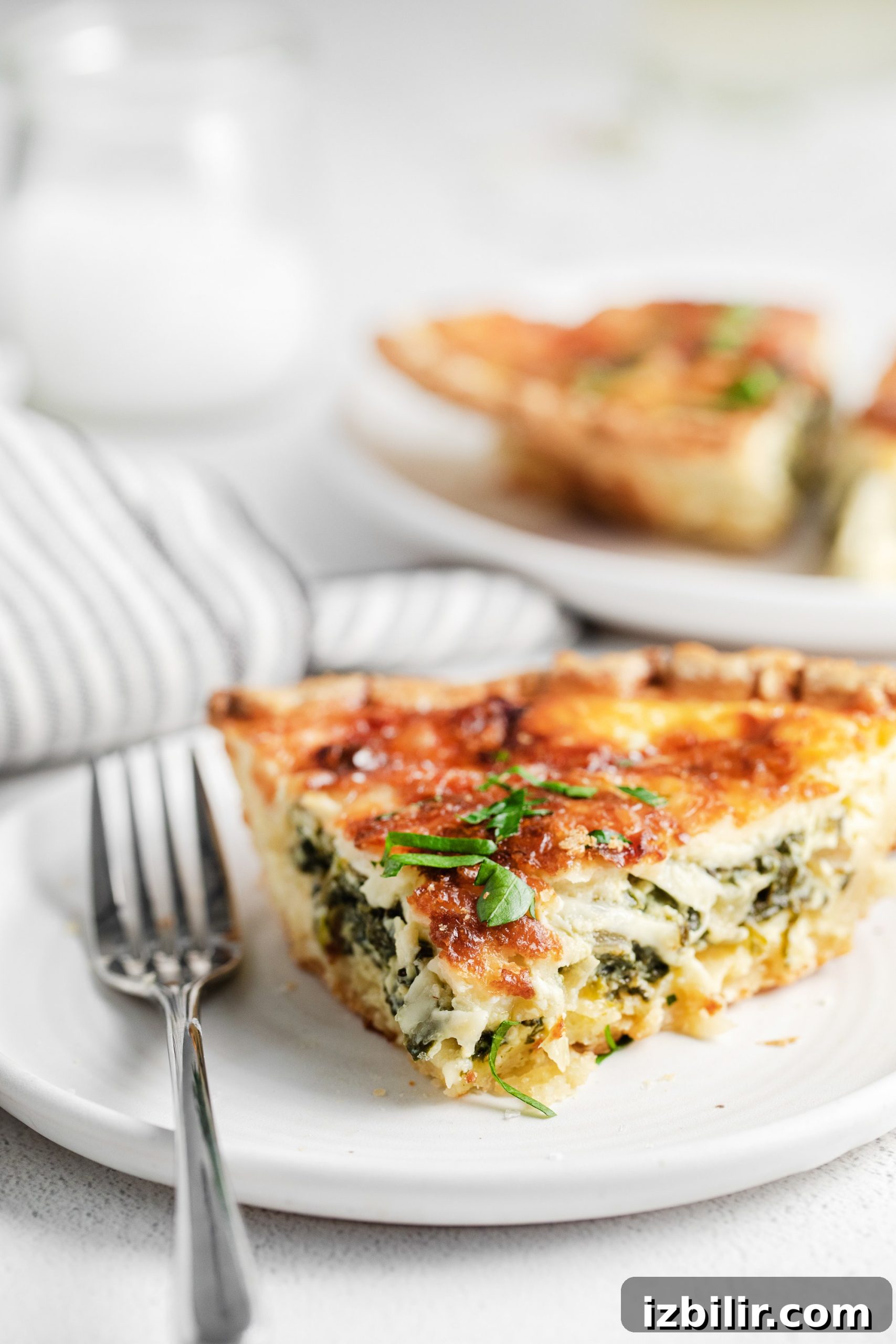 Spinach Quiche Recipe with Flaky Pastry Crust 2 A slice of quiche on a plate.