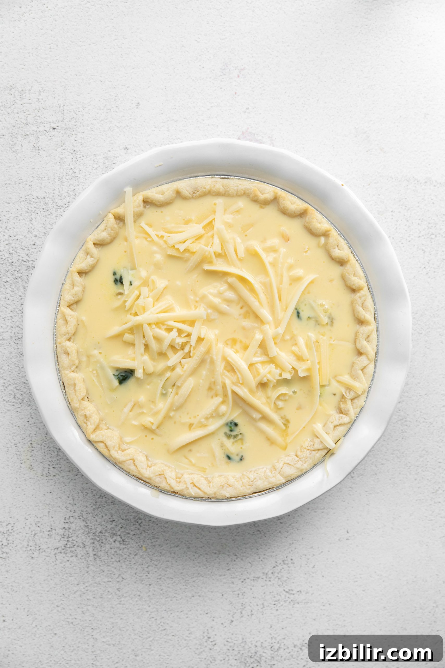 Spinach Quiche Recipe with Flaky Pastry Crust 6 Cheese sprinkled on top of a quiche.