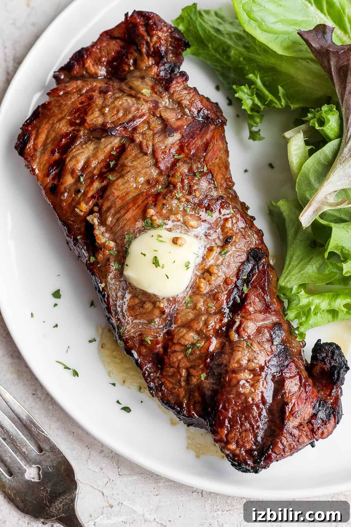 Add juicy, savory flavors to your next steak by making this easy steak marinade. This delicious steak marinade is made with Worcestershire sauce, balsamic vinegar, garlic, and a touch of lemon. steak on plate.