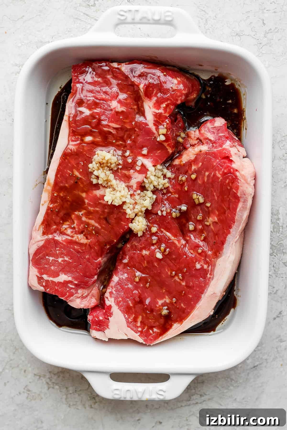 This is the ultimate steak marinade made with Worcestershire sauce, balsamic vinegar, garlic, and a little lemon juice. It'll leave your steak flavorful and juicy. steaks marinating in baking dish.