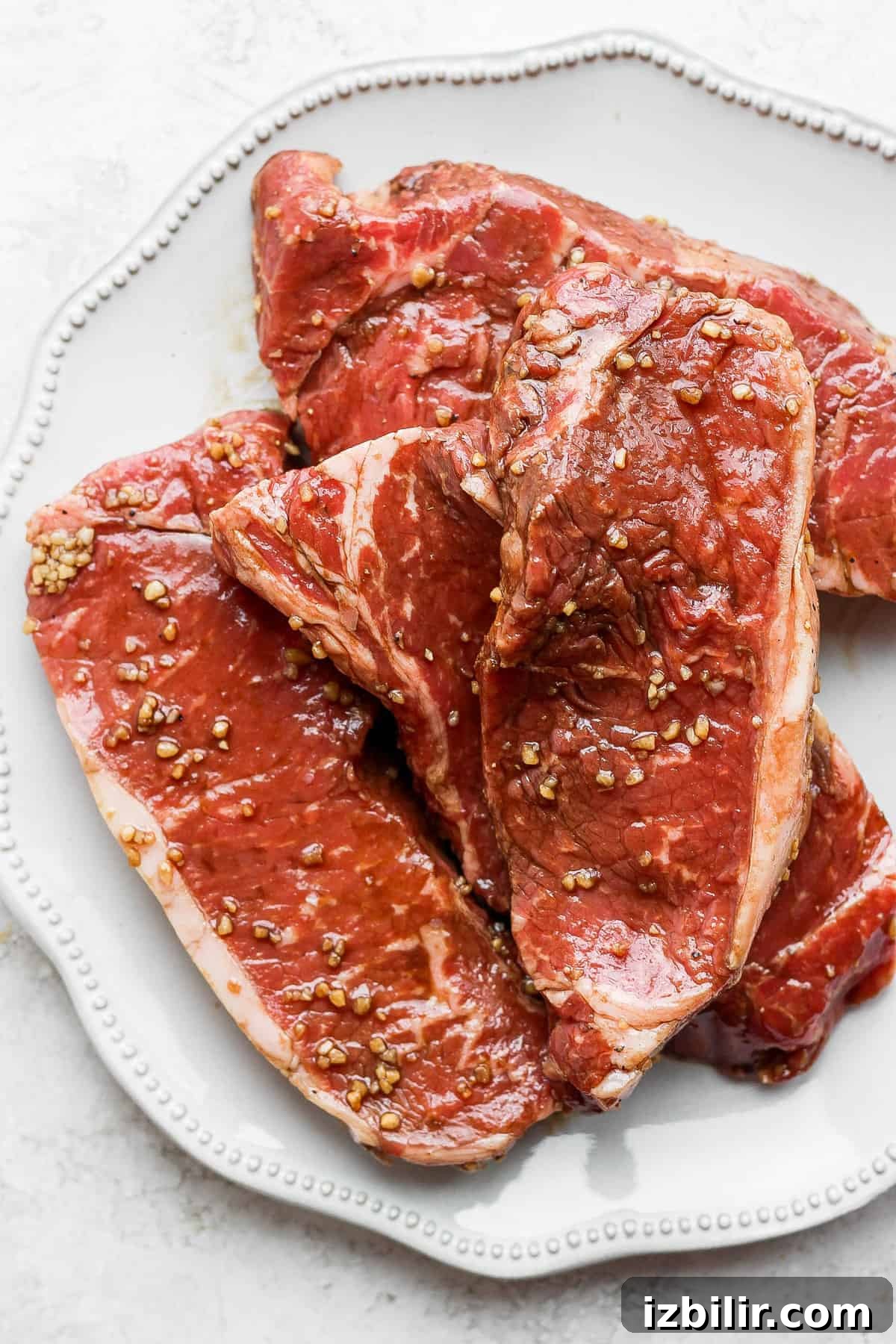 This is the ultimate steak marinade made with Worcestershire sauce, balsamic vinegar, garlic, and a little lemon juice. It'll leave your steak flavorful and juicy. marinated steaks on plate.