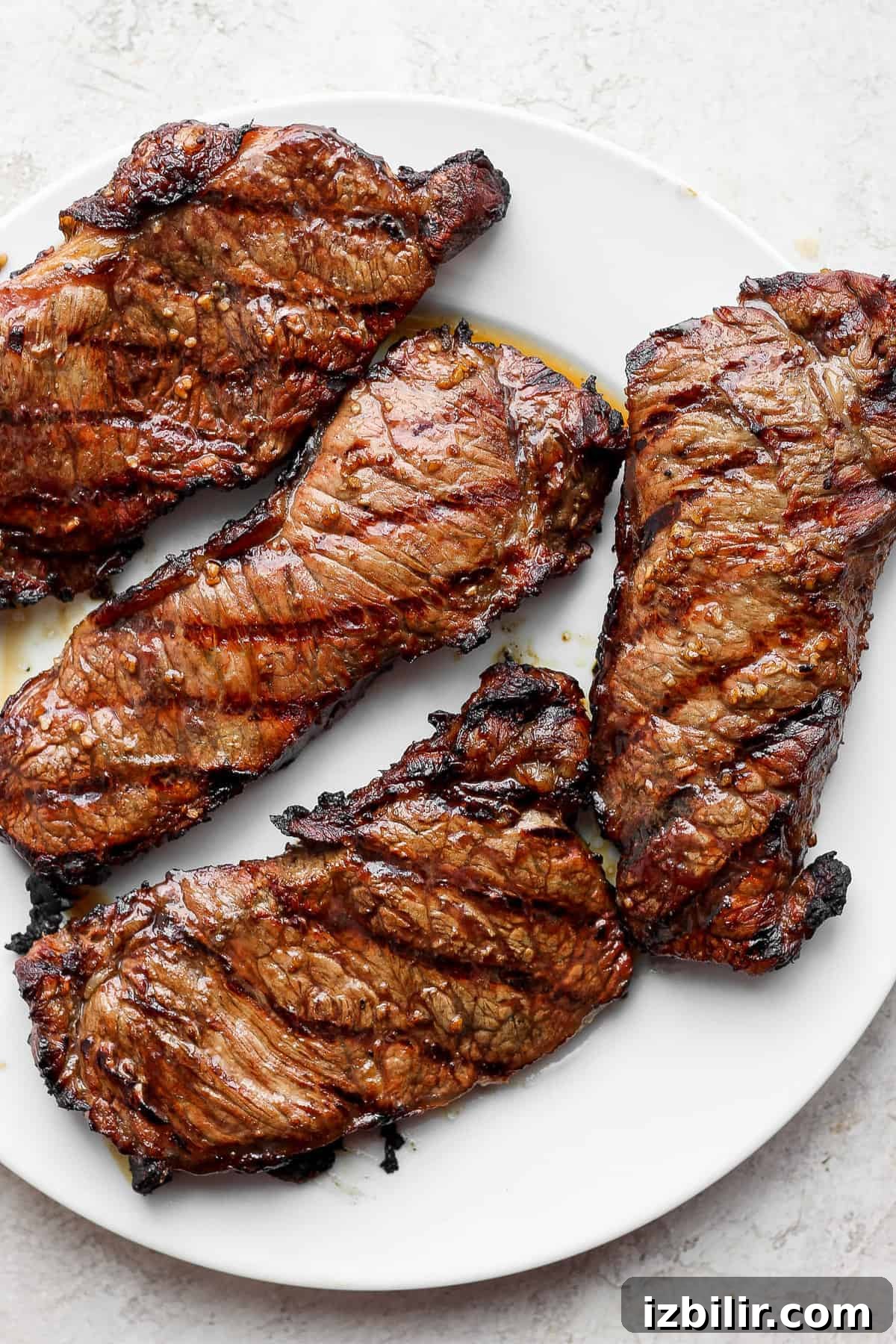 Grilled steaks plated 4 large grilled steaks on a plate.