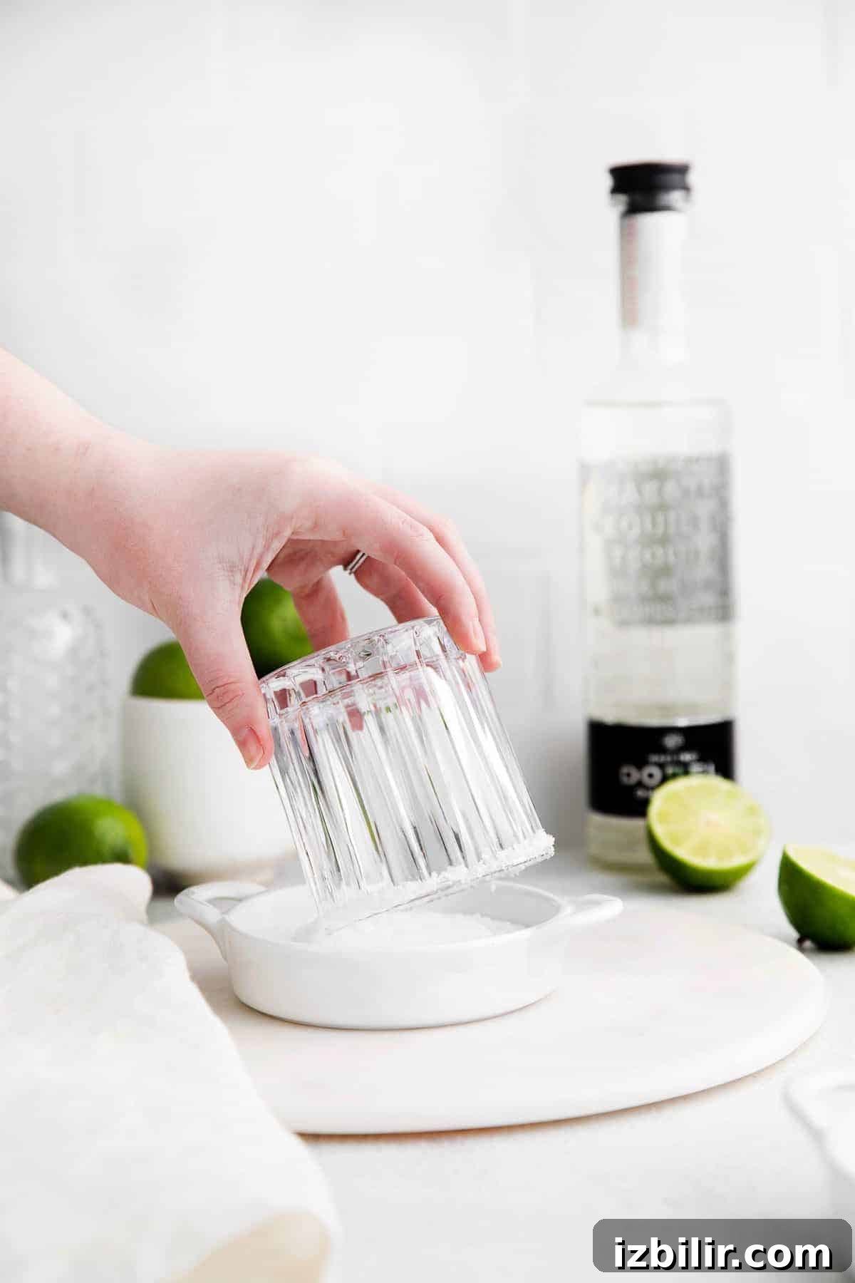 Classic Margarita Recipe: Tangy Lime and Tequila Cocktail 4 Dipping the rim of a margarita glass into salt.