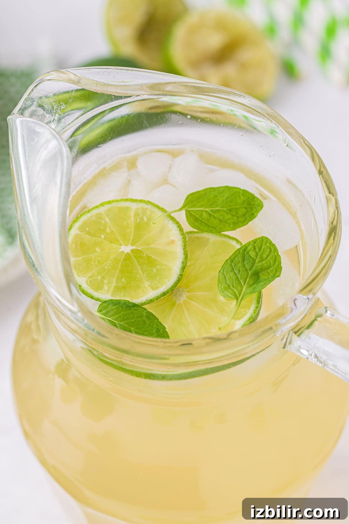 limeade in a pitcher with ice and fresh lime slices looking delicious