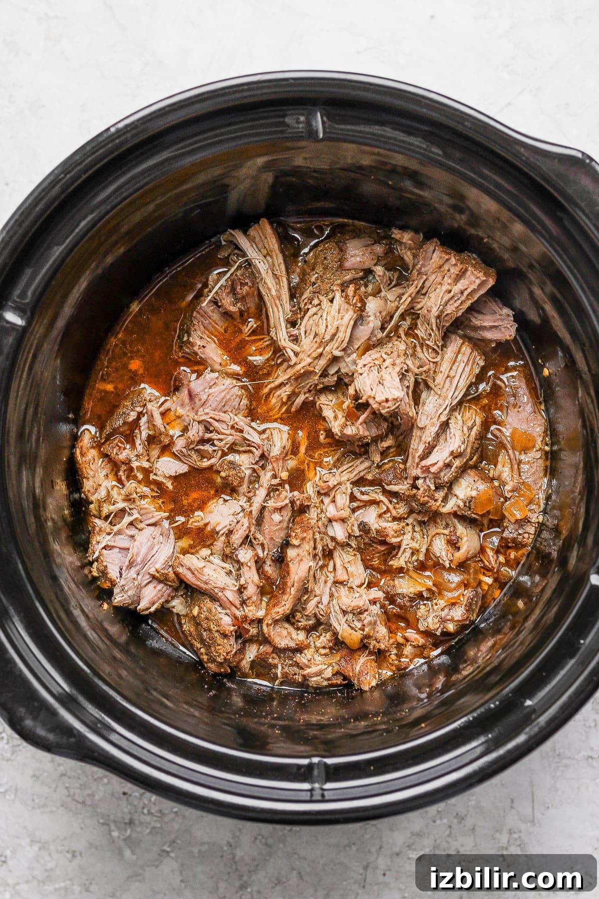 Shredded carnitas in a slow cooker. 