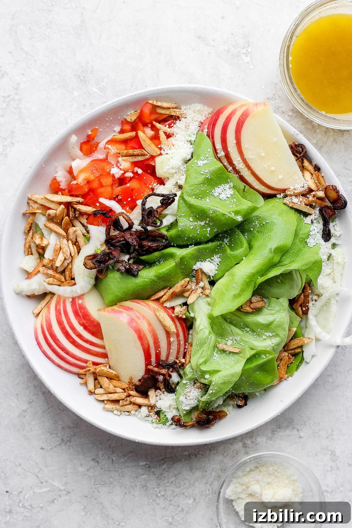 Butter Lettuce Salad with Lemon Dijon Vinaigrette 2 Butter lettuce salad with apples, peppers, slivered almonds, grated parmesan, and more in a salad bowl.