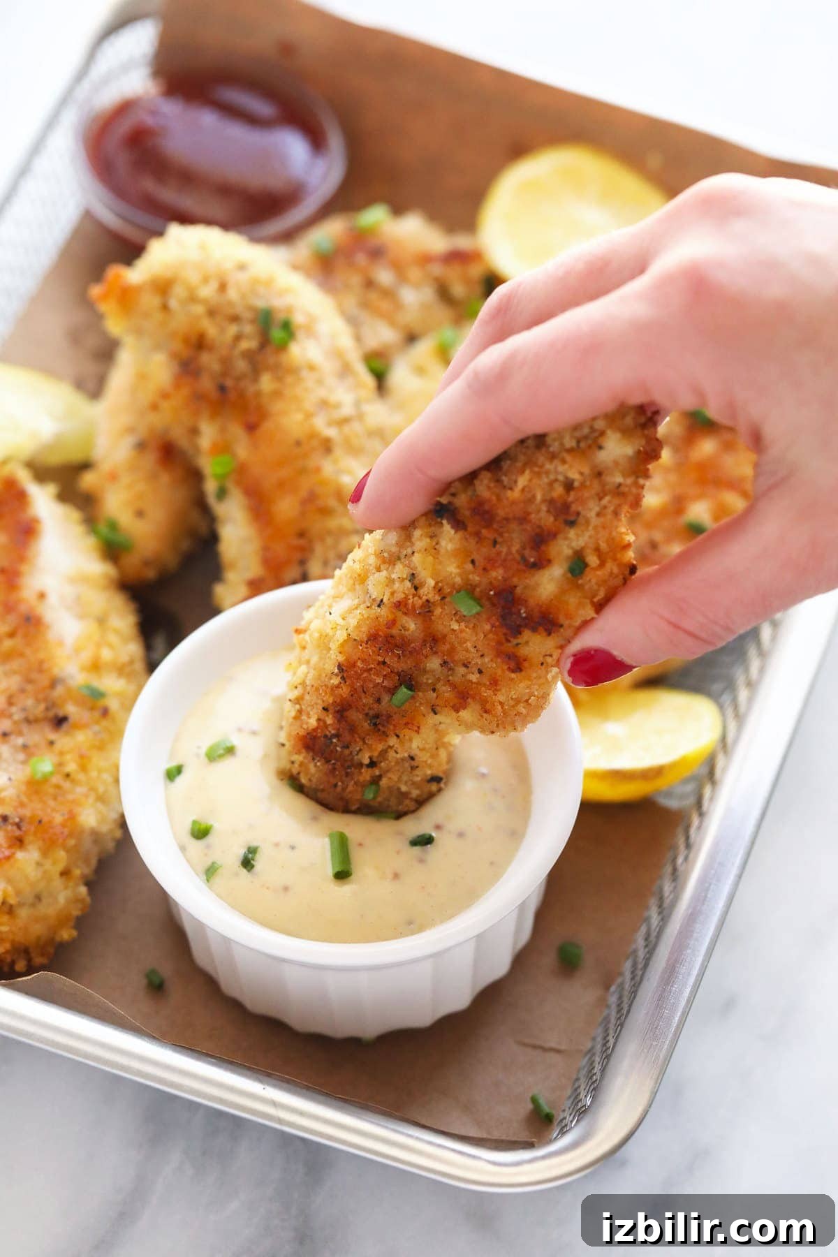 dipping chicken tenders into honey mustard