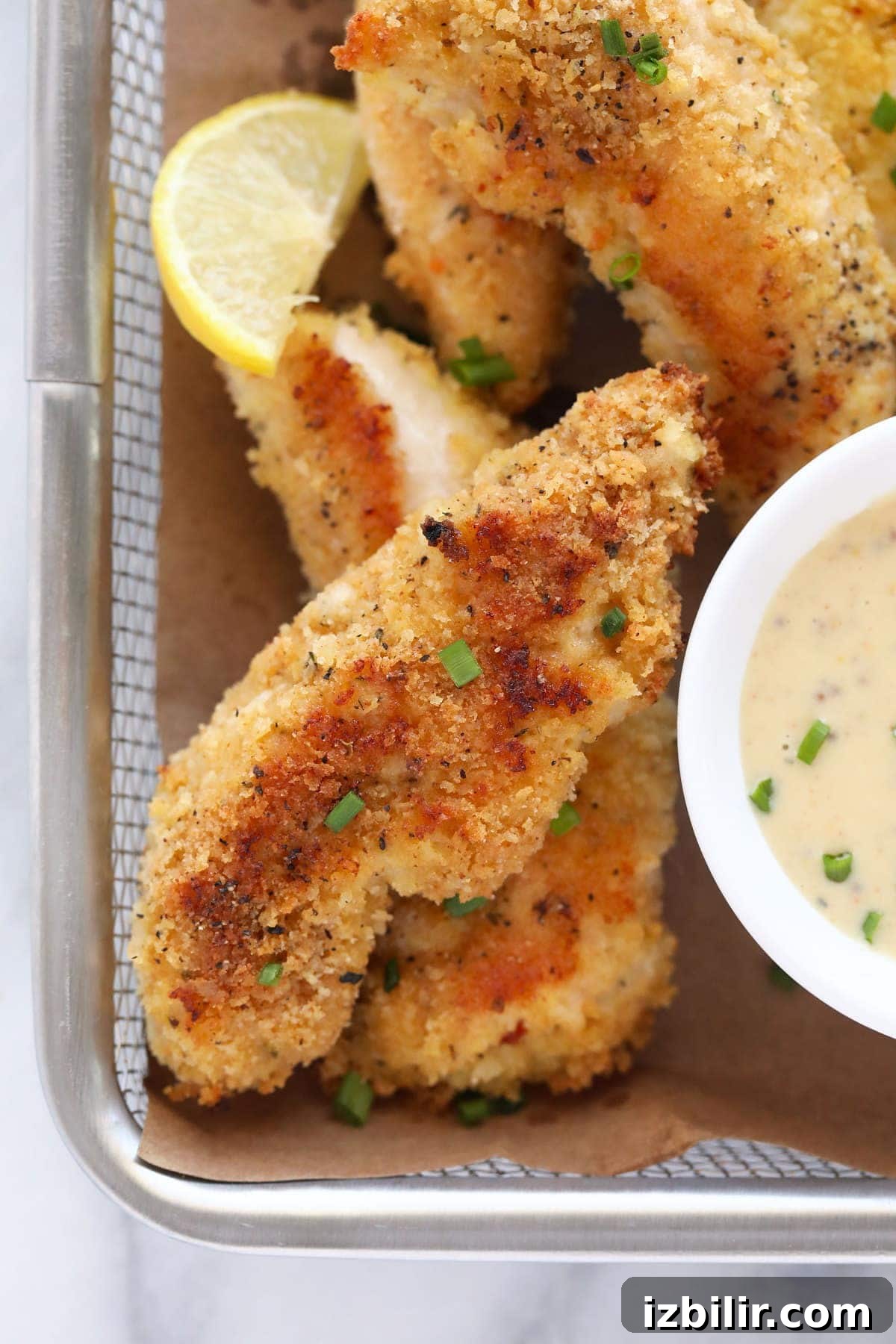 Baked chicken tenders in a basket.