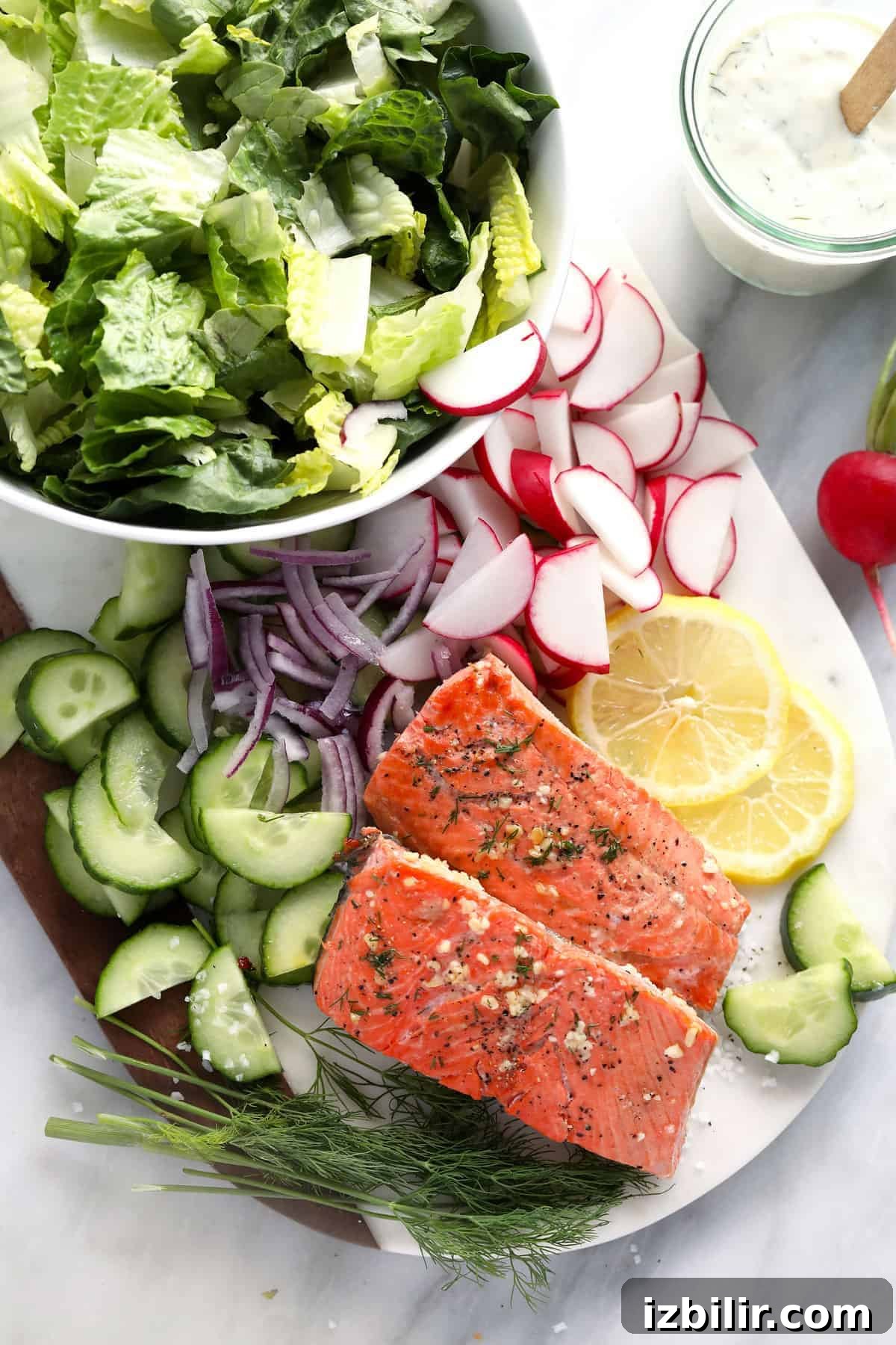 Veggies, lemon, and cooked salmon in cutting board.