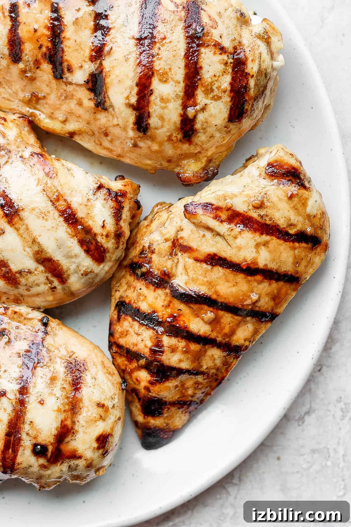 Grilled Bruschetta Chicken Recipe with Tomato Basil Topping 4 Grilled chicken breasts on a plate.