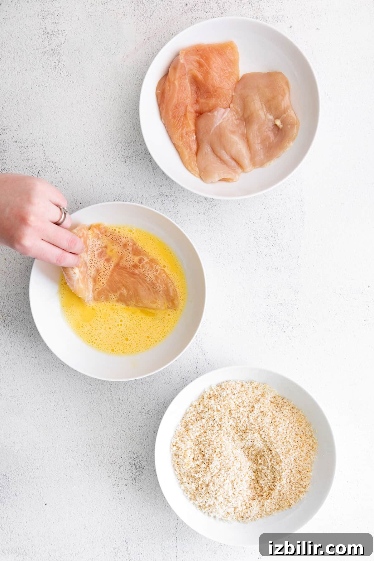Dipping chicken in egg wash Dipping chicken breast in egg wash.