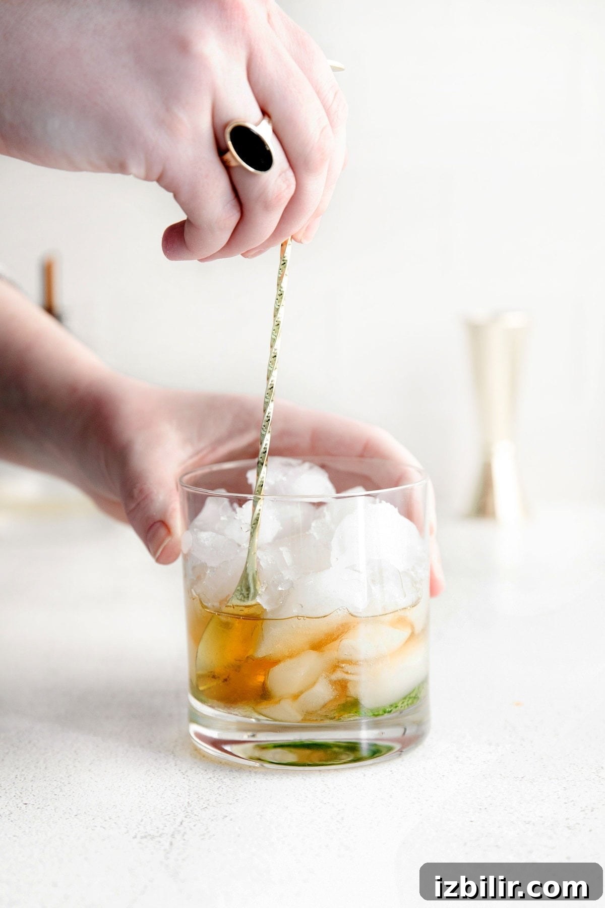 Classic Bourbon Mint Julep Cocktail Recipe 6 bourbon being stirred into a glass of ice with muddled mint for a mint julep.