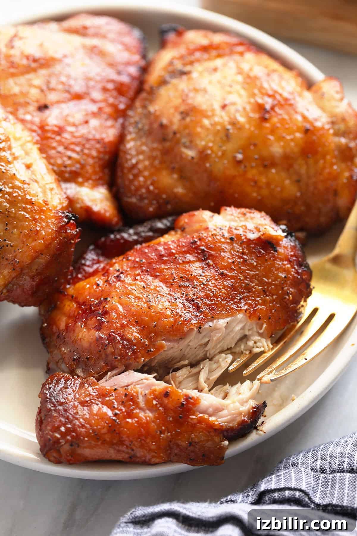 How to Smoke Chicken Thighs for Juicy, Crispy Skin 2 Smoked chicken thighs on a plate.