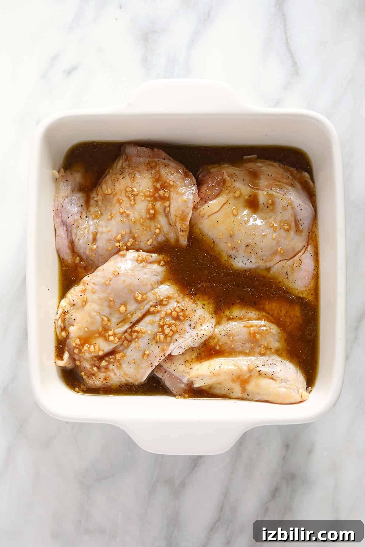 How to Smoke Chicken Thighs for Juicy, Crispy Skin 4 Chicken thighs marinating.