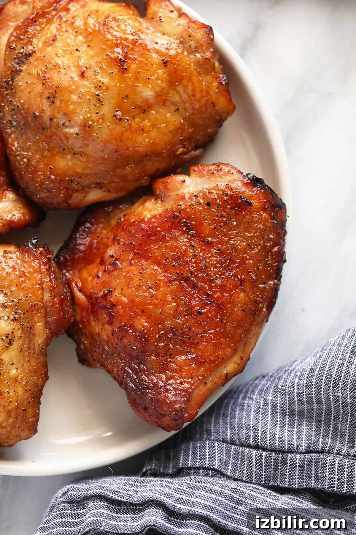 How to Smoke Chicken Thighs for Juicy, Crispy Skin 7 Smoked chicken thighs on a plate.