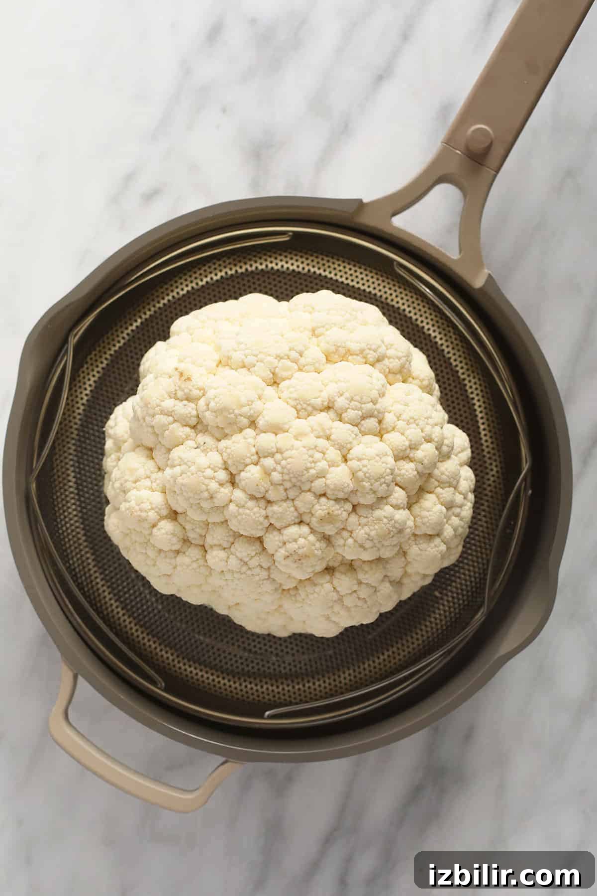 A head of cauliflower in a steamer.