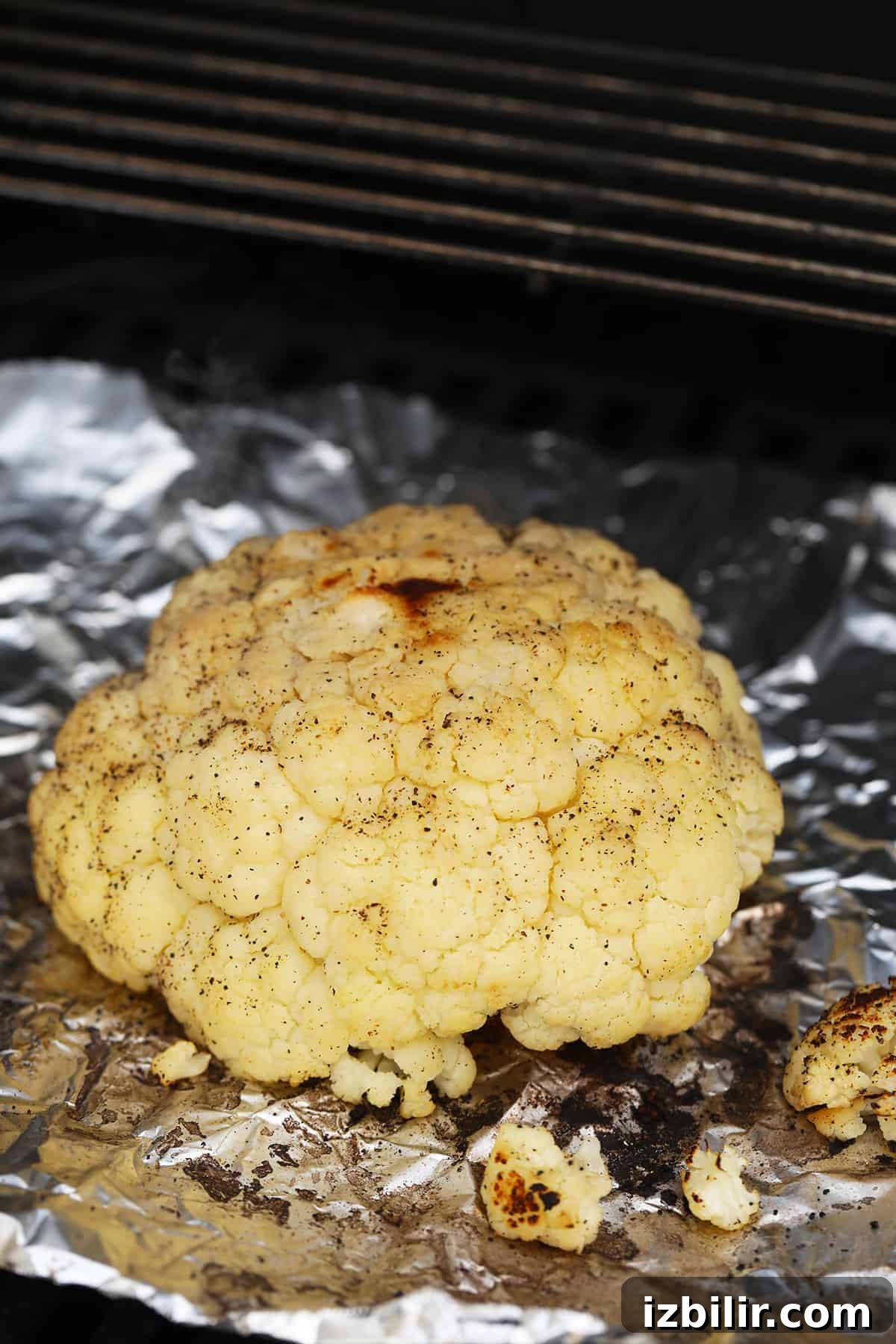 A whole head of cauliflower on the grill.