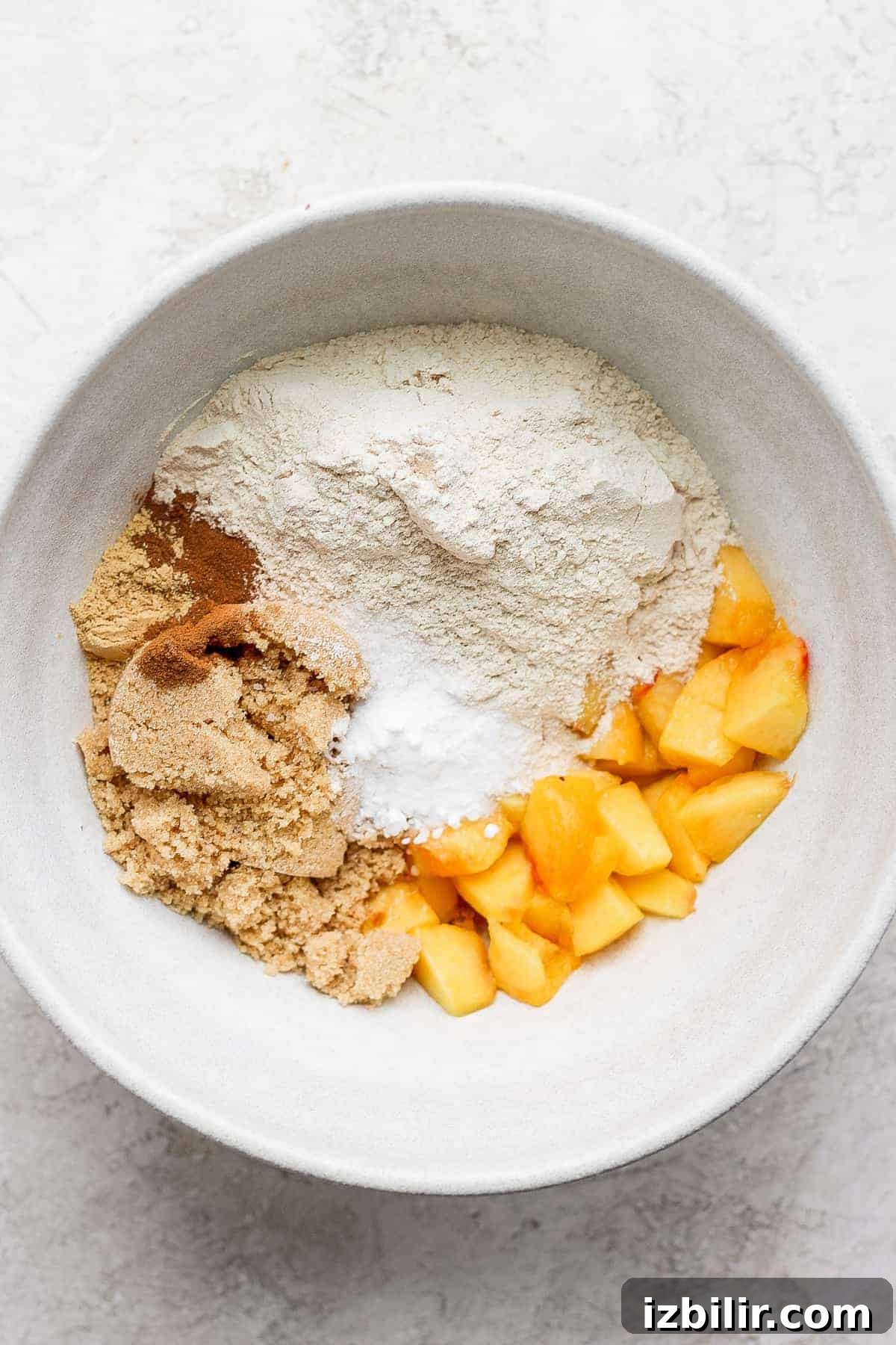 Peach muffin ingredients ready to be combined. peach muffin ingredients in a bowl ready to be mixed together